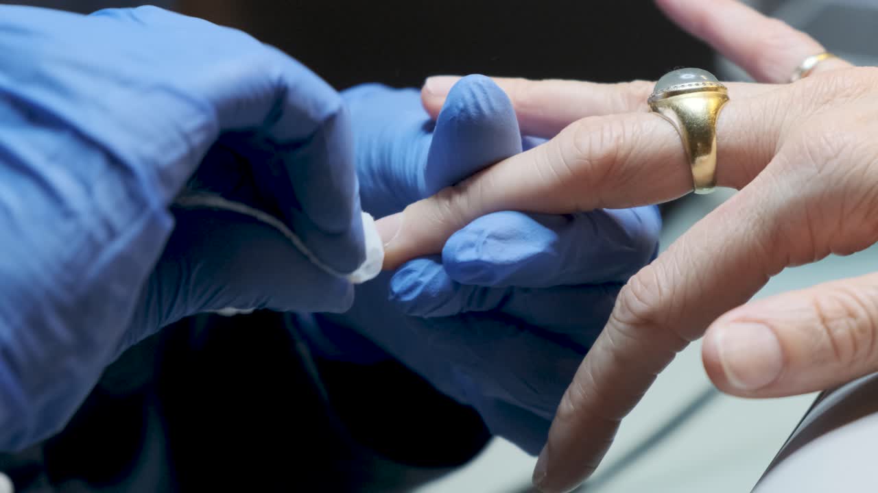 미용사가 손톱을 닦는 모습을 가까이서 볼 수 있는 미용실에서 네일 매니큐어를 바르고 있는 여성