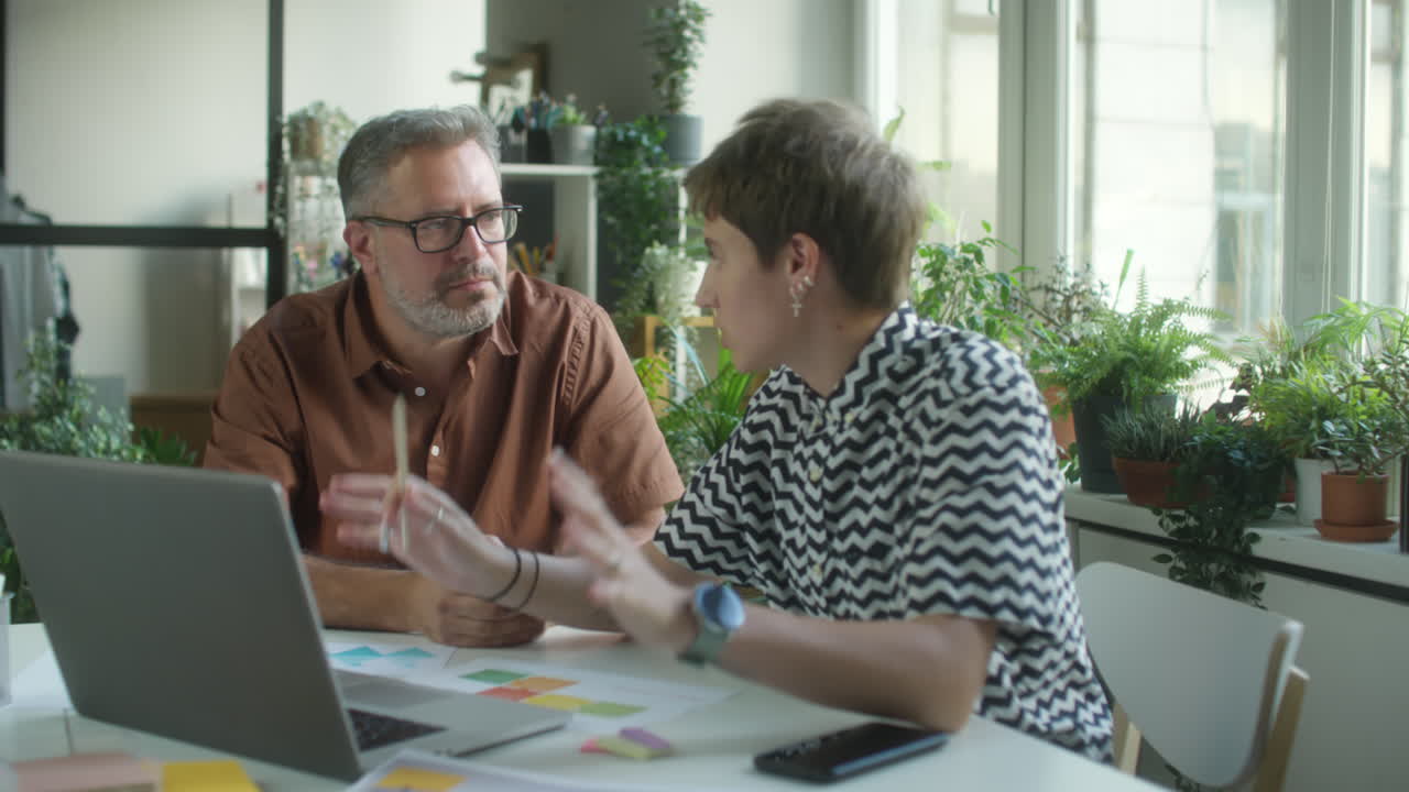 Kolegové diskutující o projektu na notebooku