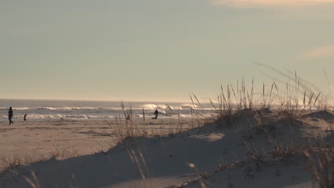 Menschen-An-Der-Küste-Mit-Wellen,-Die-Auf-Einen-Sonnenuntergang-Rollen---Atlantischer-Ozean-In-New-Jersey---Weitwinkelaufnahme