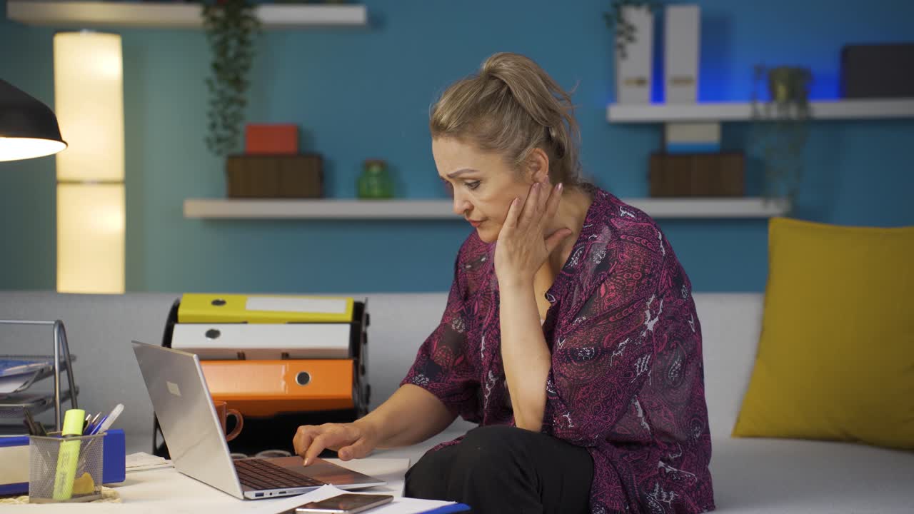 홈 오피스 직원 노트북에서 일하는 여성이 스트레스를 받습니다.
