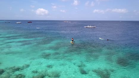 Stand-up-paddler-stands-on-surfboard