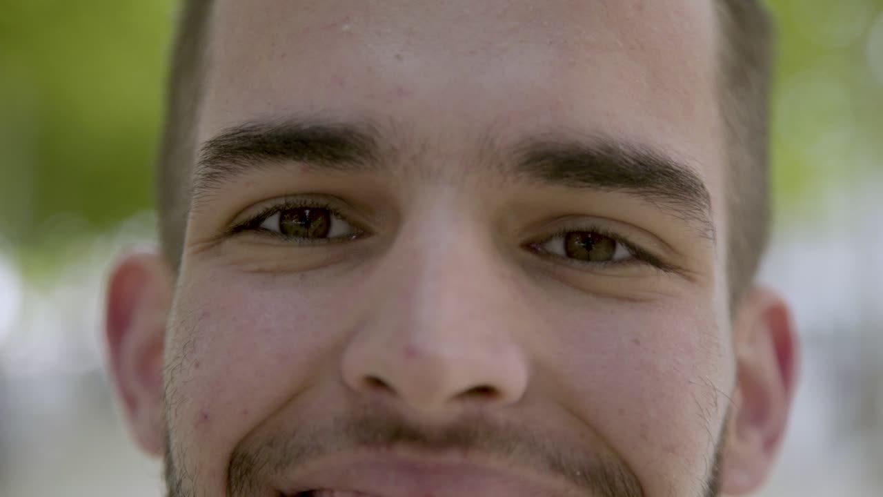 disparo en primer plano de un joven sonriente mirando a la cámara