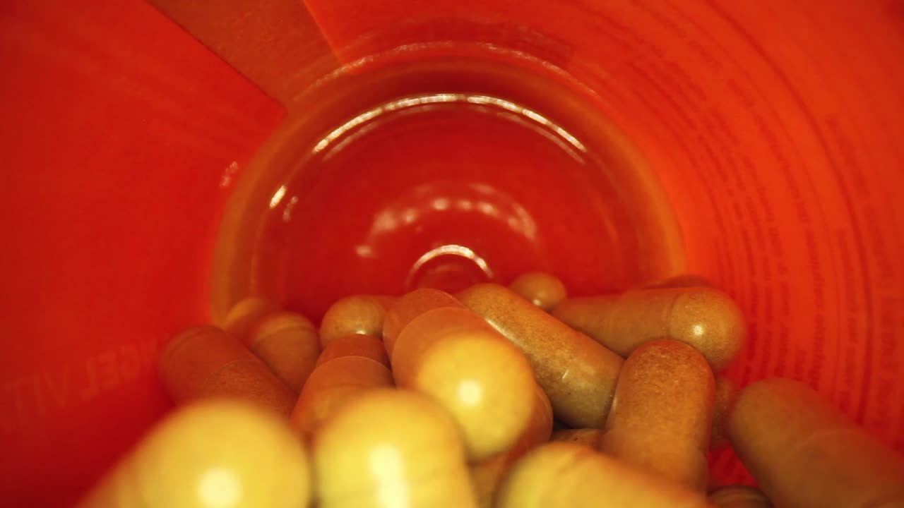 주황색 보충제 약병에 천천히 밀어 넣습니다.