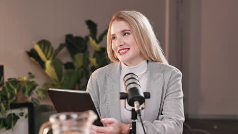woman recording podcast with tablet and microphone