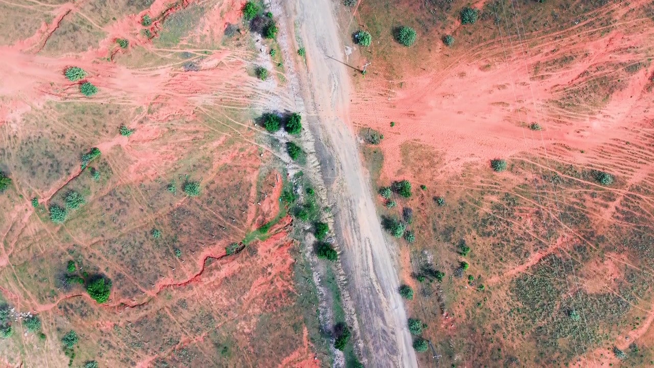A Hoa Thang, Lam Dong, la terra rossa brilla sotto il sole. Strade polverose si estendono attraverso il paesaggio. Piccoli alberi punteggiano l'area.