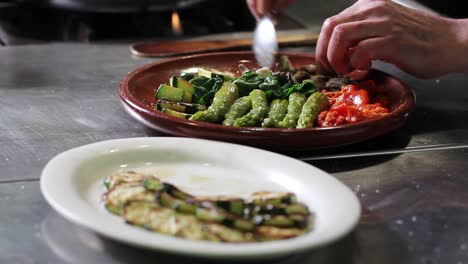 Placing-mushrooms-over-the-clay-plate-while-preparing-the-salad,-with-zucchini-waiting-to-be-placed