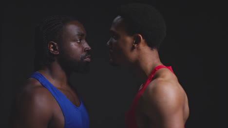 cerca de dos boxeadores masculinos que se enfrentan cara a cara antes de un partido de boxeo mirando fijamente a la cara del oponente y hablando basura