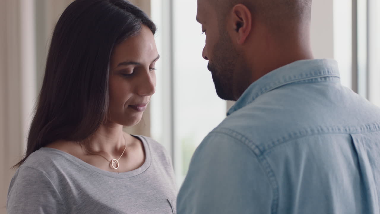 feliz pareja de raza mixta abrazando a una hermosa mujer abrazando a su novio compartiendo una relación amorosa íntima en casa