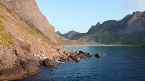 Drone-shot-of-remote-Horseid-sand-beach-surrounded-by-steep-cliffs-in-Norway-Lofoten