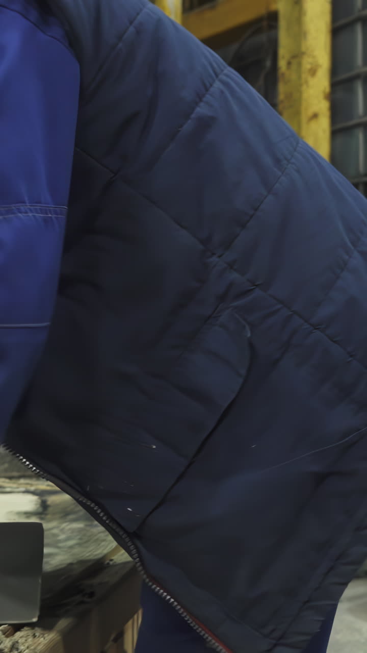 Worker engaged in material handling and preparation in an industrial setting