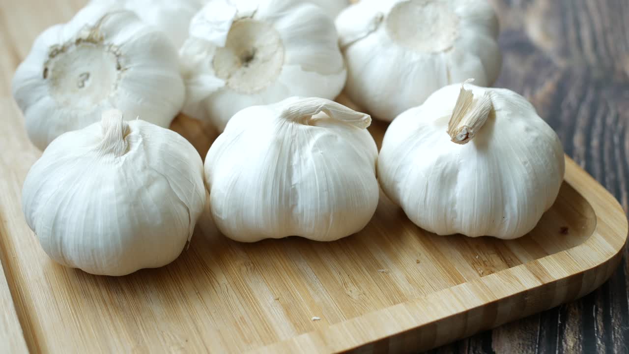나무판 위에 있는 신선한 마늘 질의 클로즈업