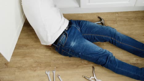 hombre reparando un fregadero de cocina