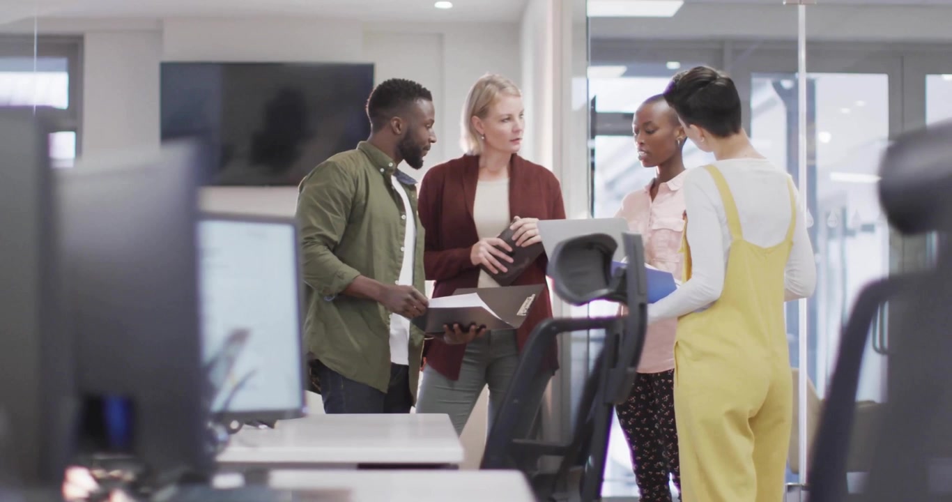 Business colleagues discussing on laptop inducing animated icons flooding and fading around them