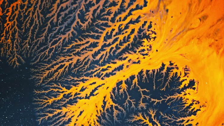 Abstract swirling alcohol ink on dark surface creating a striking orange and blue pattern