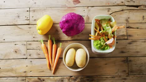 overhead video of unprepared vegetables and organic waste in kitchen composting bin