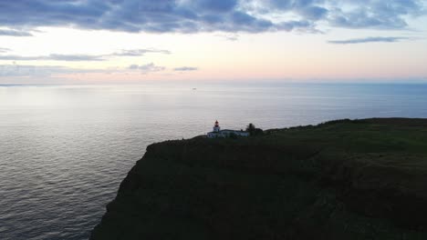 aerial view of farol da ponta do pargo lighthouse at sunset, located on a cliff overlooking the atlantic ocean in madeira, portugal