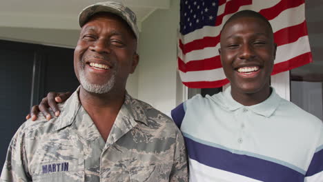 video of happy african american senior soldier and his son looking at camera