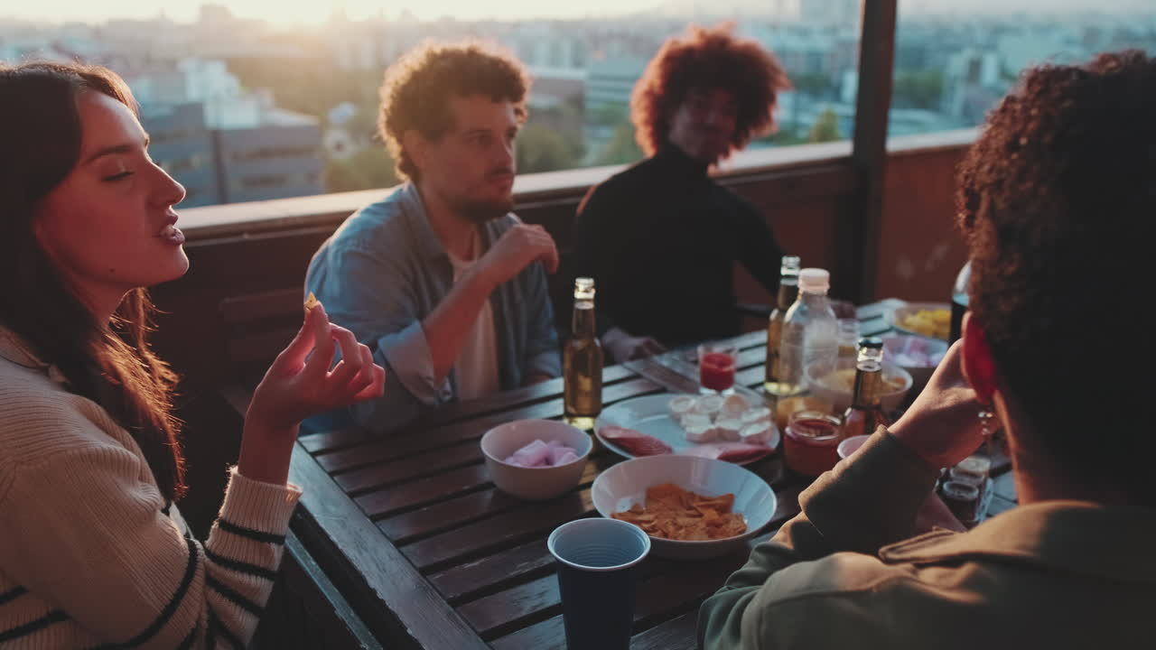 Friends having a rooftop party at sunset
