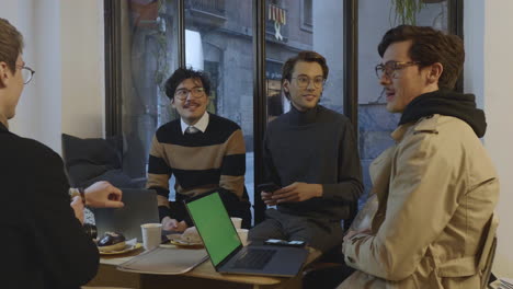 Businessmen-having-meeting-in-cafe.-Coworkers-working-on-laptop-computers