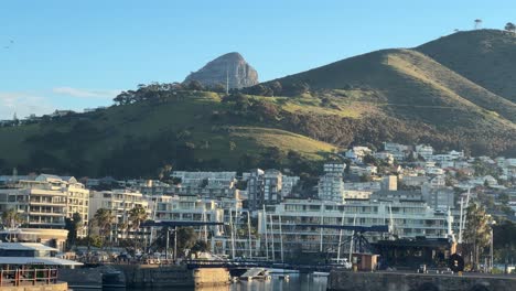 view of lions head peaking out from behind signal hill in cape town, south africa