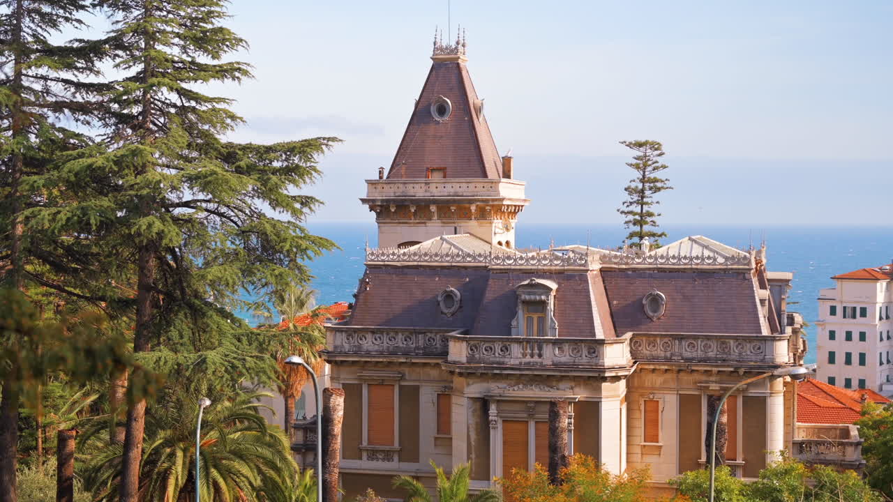 Un’antica dimora in stile classico, costa del Mar Mediterraneo sullo sfondo, vegetazione a Sanremo, Italia
