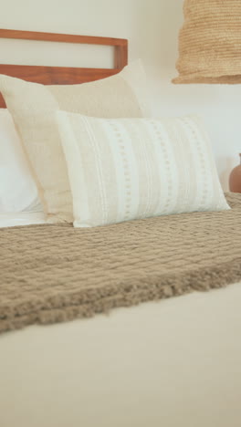 vertical video: cozy bedroom with woven blanket and decorative pottery creating serene atmosphere