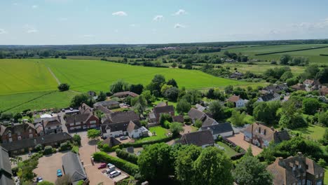 an upward boom-shot of the st john the evangelist church steeple, rising to unveil the village of ickham