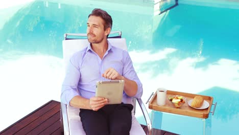 handsome man using tablet on deck chair