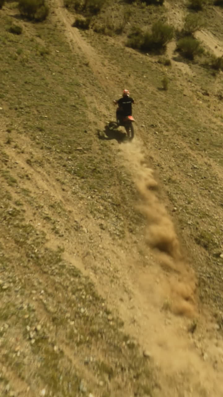 maniobras de motociclista en la colina descuidada en motocross fpv. moto deportista monta motocicleta en las tierras altas del desierto en un día de verano. explorar área virgen en vehículo