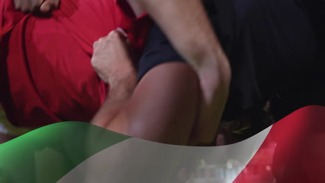 animation of flag of italy over diverse male rugby players playing rugby