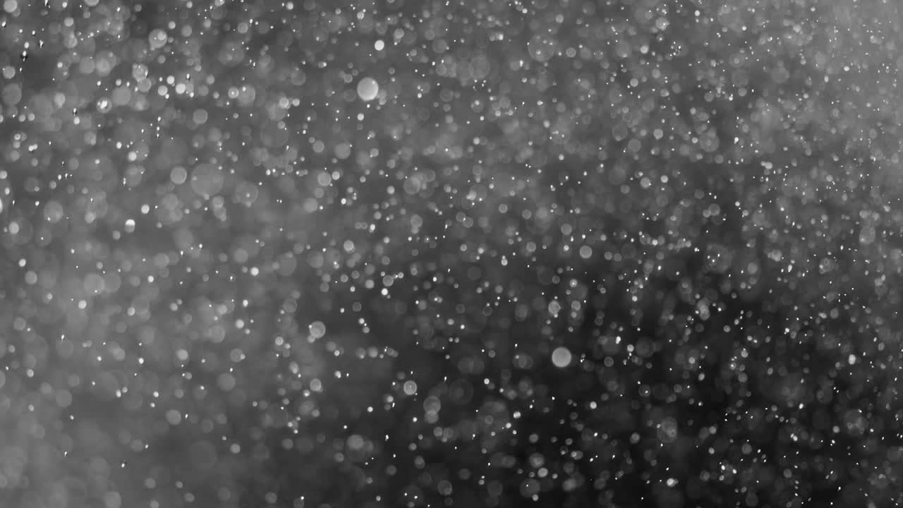 Floating abstract particle bokeh on dark background. Shot on super slow motion camera 1000 fps.