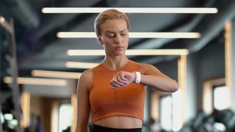 tired athlete girl checking results at gym. sportswoman standing in sport club