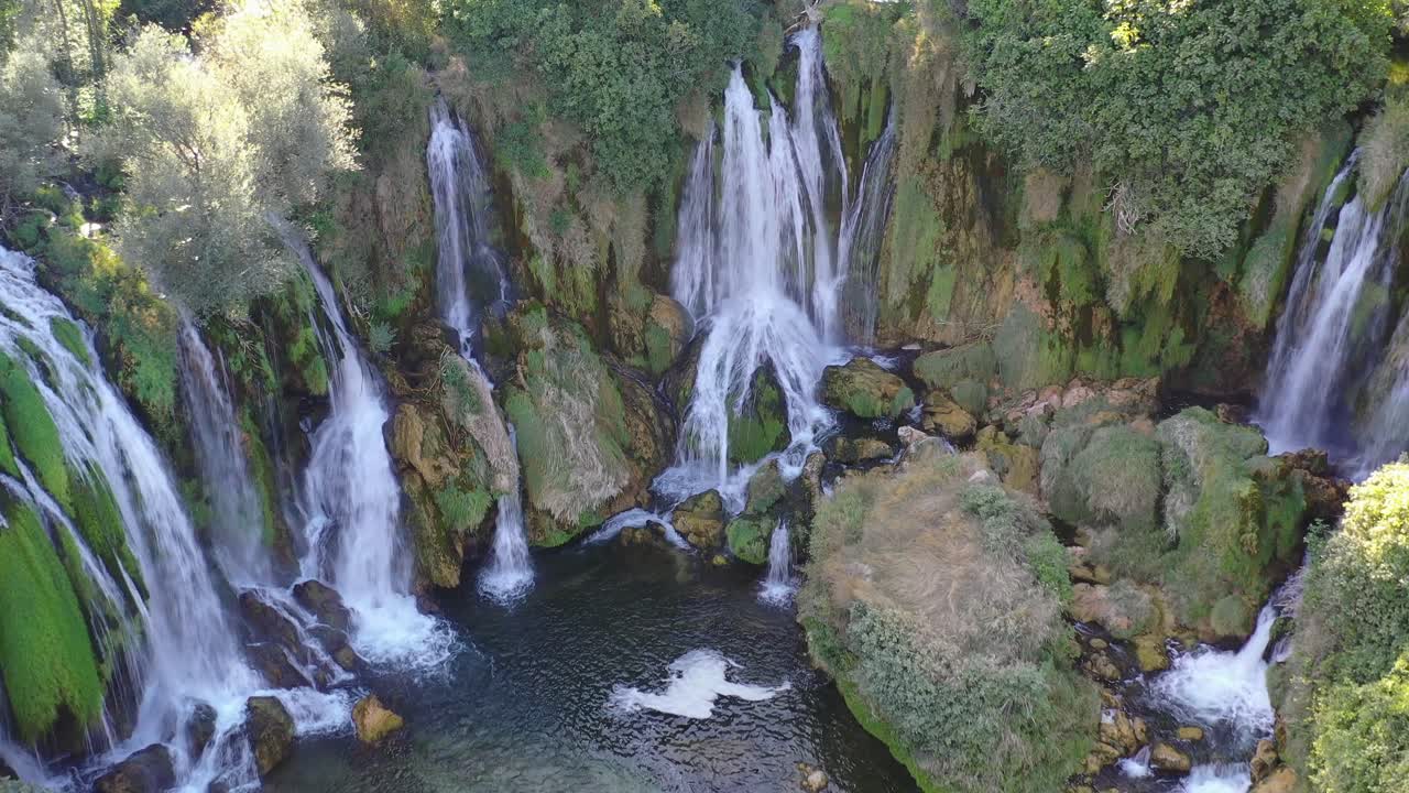Kravica Waterfall with male female couple on a kayak below enjoying the sights, Aerial flyover shot