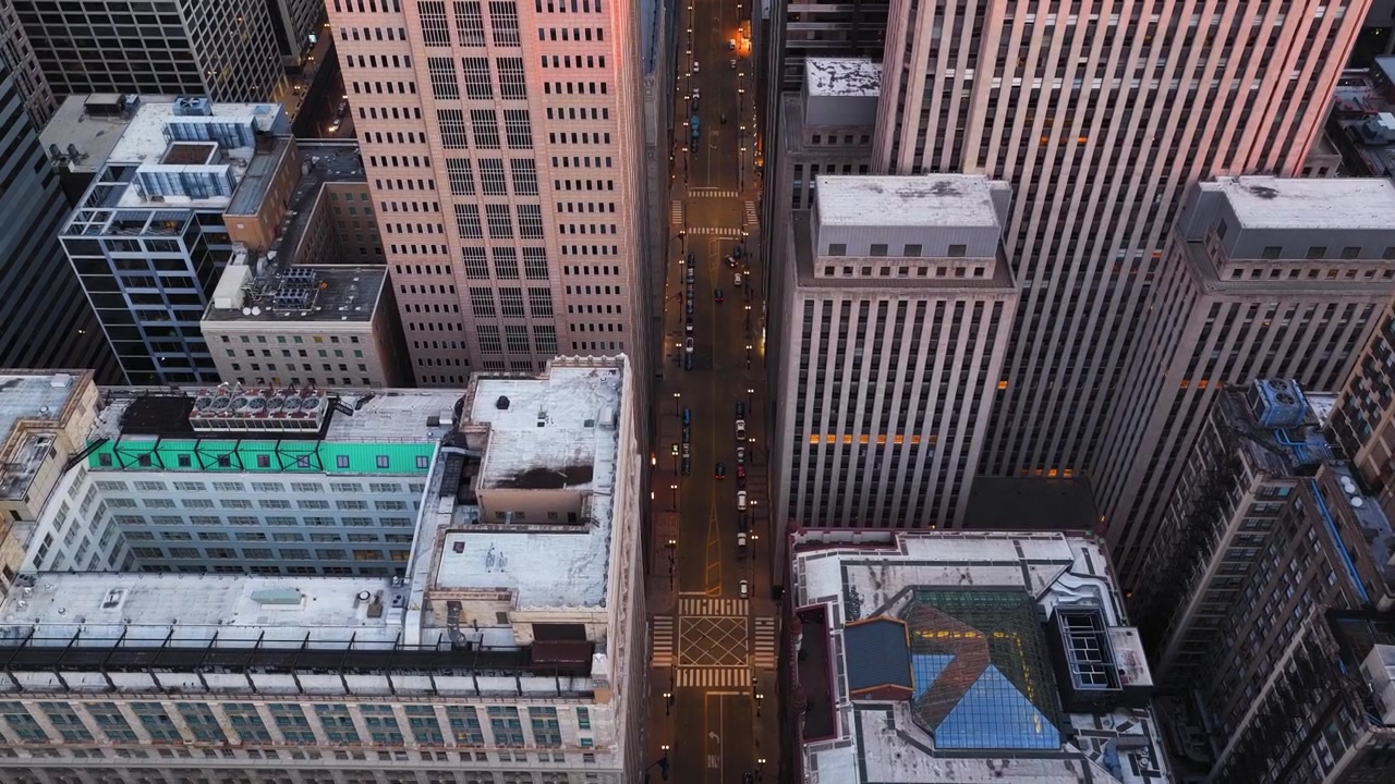 Ripresa aerea con drone dall'alto che si inclina su una strada cittadina vuota, alba a Chicago, USA.