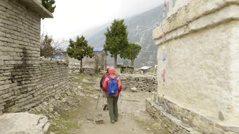 mochileros caminando en el pueblo nepalés. área de senderismo del circuito de manaslu.