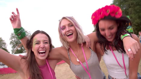 three young female friends having fun at a music festival