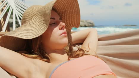 Front-view-of-Caucasian-woman-relaxing-in-a-hammock-at-beach-4k