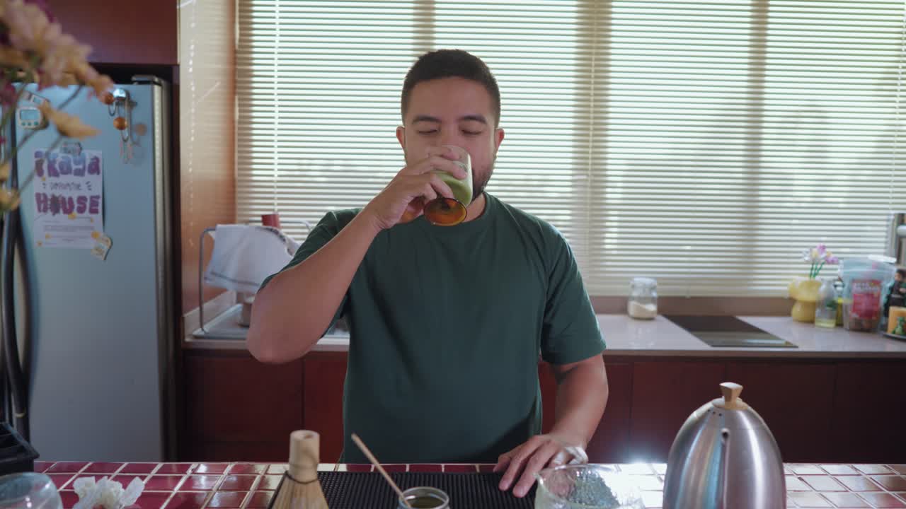 Man Drinking Matcha Latte in Kitchen
