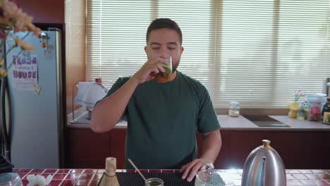 man drinking matcha latte in kitchen