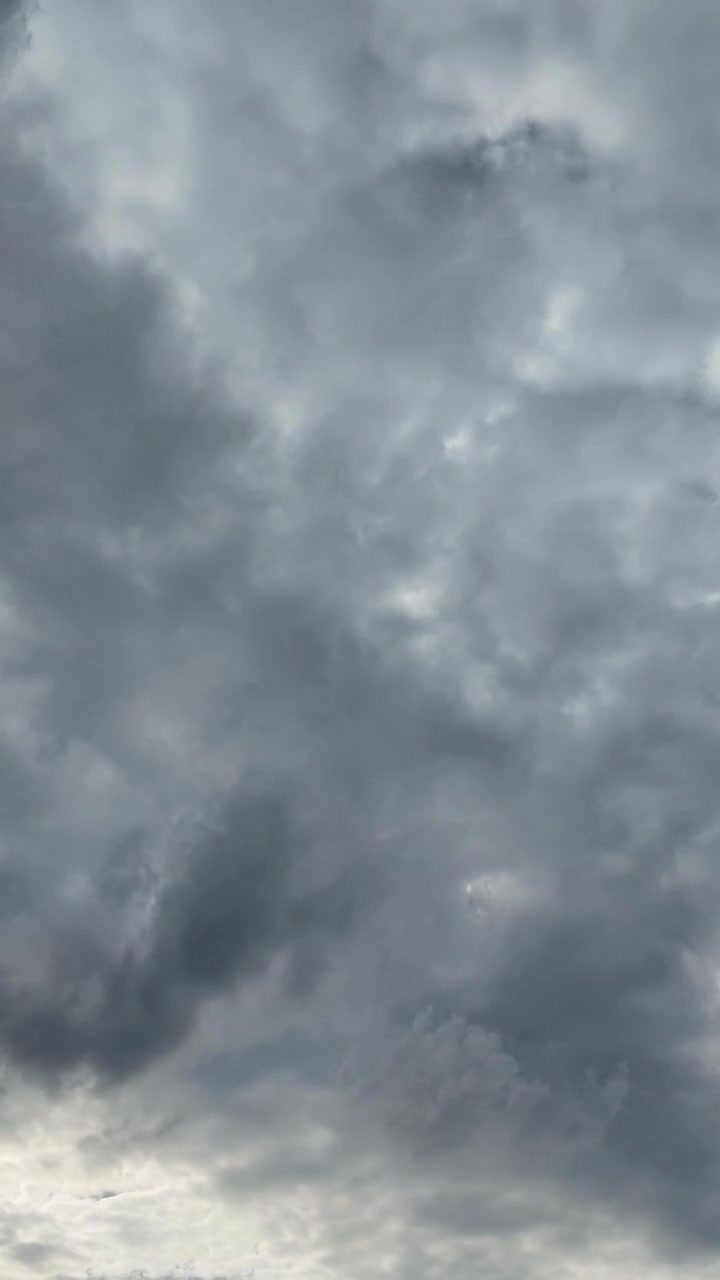 Awan badai abu-abu dramatis berputar-putar di langit mendung. Ideal untuk laporan cuaca, tema lingkungan, dan penceritaan berbasis suasana hati.