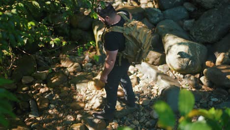 Male-hiker-walking-in-the-jungle-surounded-by-boulders-and-trees