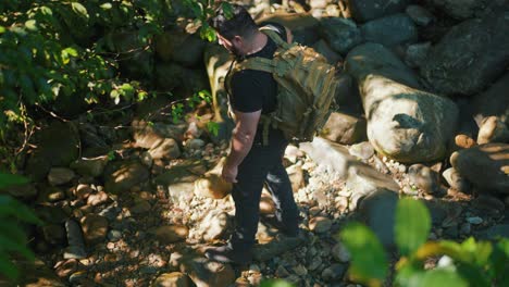 excursionista masculino caminando en la jungla rodeado de rocas y árboles