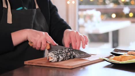 making sushi at home kitchen. woman hands rolling homemade sushi.