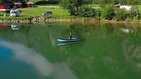 Woman-on-the-boat-catches-a-fish-on-spinning-in-Norway.