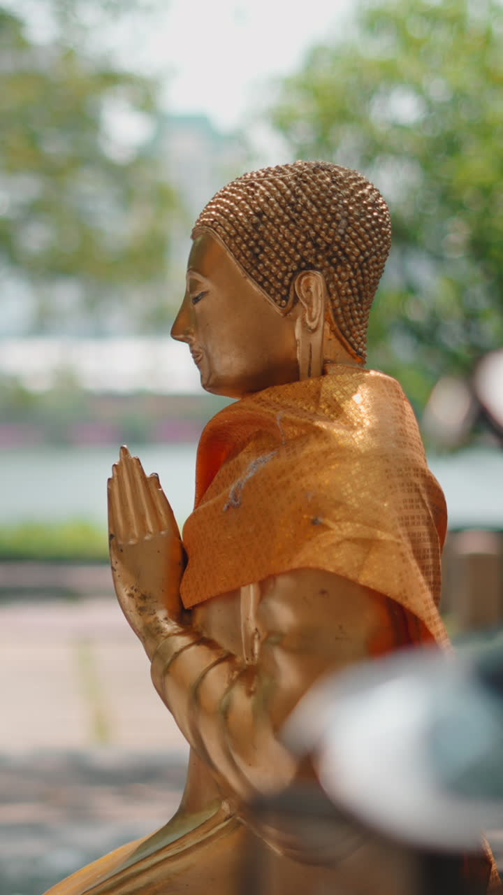 Young Women Praying Before a Golden Buddha Statue