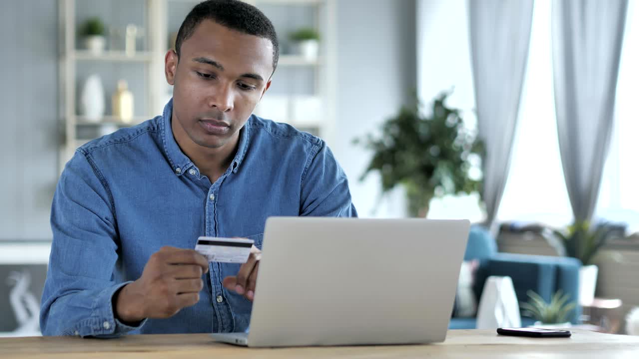 Online Shopping on Laptop by Young African Man