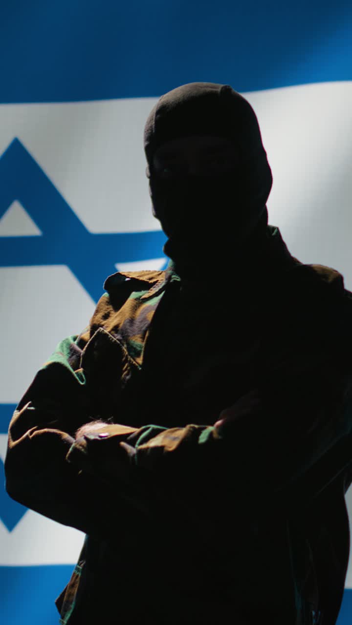 Video verticale: agente del Mossad in piedi fiero davanti alla bandiera di Israele.