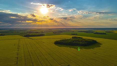 sunbeams breaking through dramatic clouds above patchy yellow fields at sunset hyperlapse