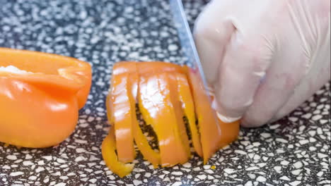 Close-up-of-hands-slicing-yellow-bell-pepper-on-wooden-cutting-board-4K