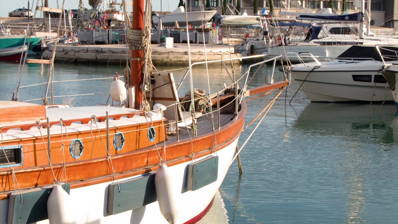 Inquadratura media statica di uno yacht in legno d'epoca attraccato in un tranquillo porto francese